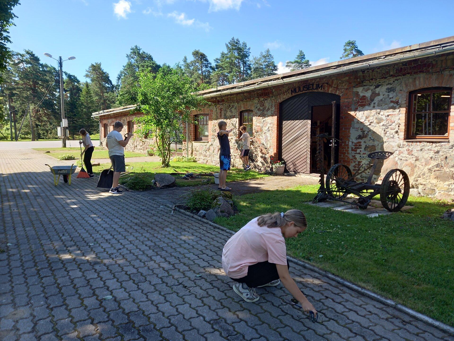 Paikuse Õpilasmalev muuseumi õueala koristamas (Krista Mustonen).